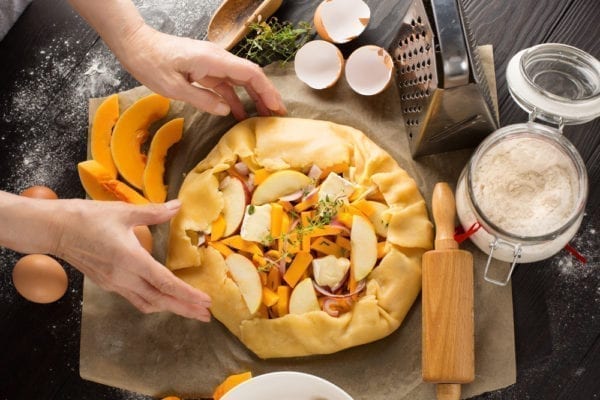 Mürbeteig mit den Händen um die Kürbis-Füllung drücken.