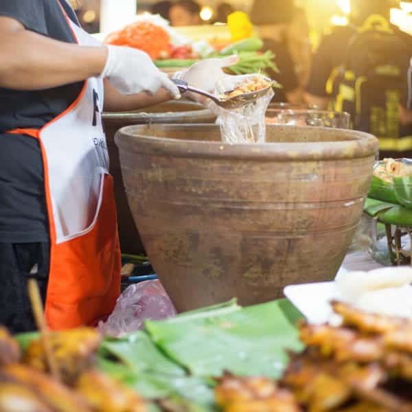 Der authentische Papayasalat Som Tam wird in riesigen Tonmörsern zubereitet