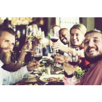 Kulinarisches Firmenevent – Lachende Kursteilnehmer stoßen mit Wein an