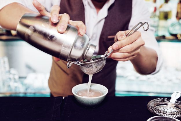 Cocktailkurs Berlin - Bartender seiht Drink ab