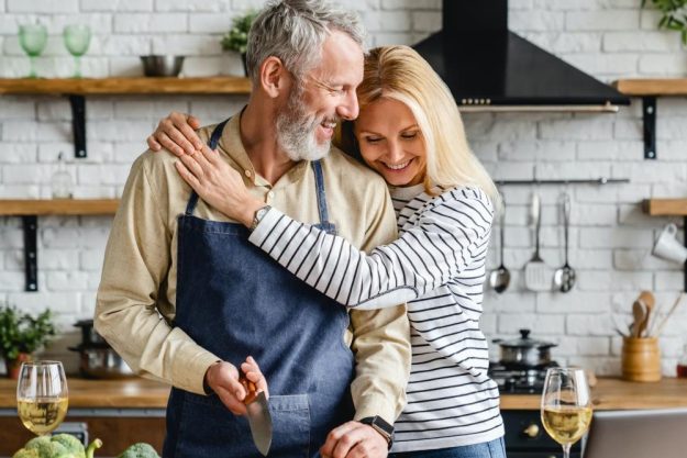 Kochkurs Stuttgart – Frau umarmt Mann beim Kochen