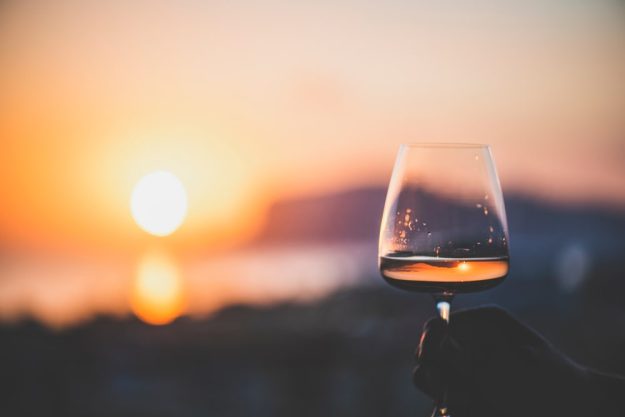 Wine tasting Munich – glass of wine by sea at sunset