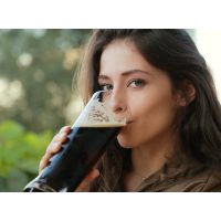 Braukurs München - Junge Frau genießt dunkles Weißbier