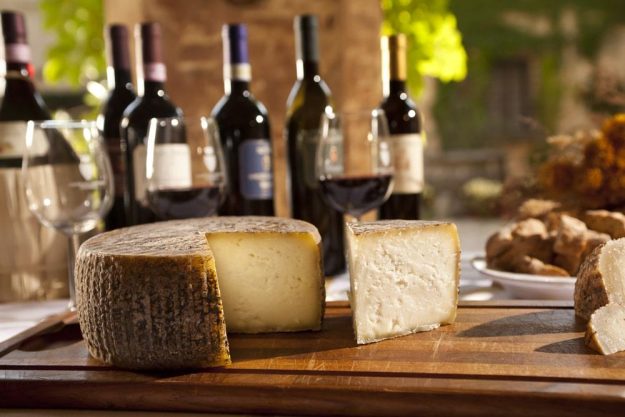 Wein- und Käse-Tasting Berlin – Weinflaschen und Käselaib