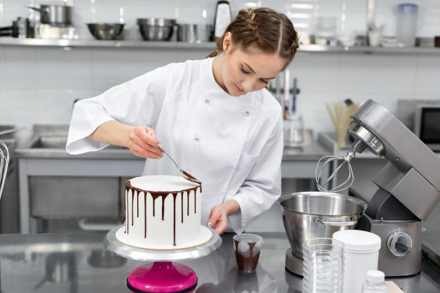 Tortenkurs Würzburg – Frau verziert Drip Cake