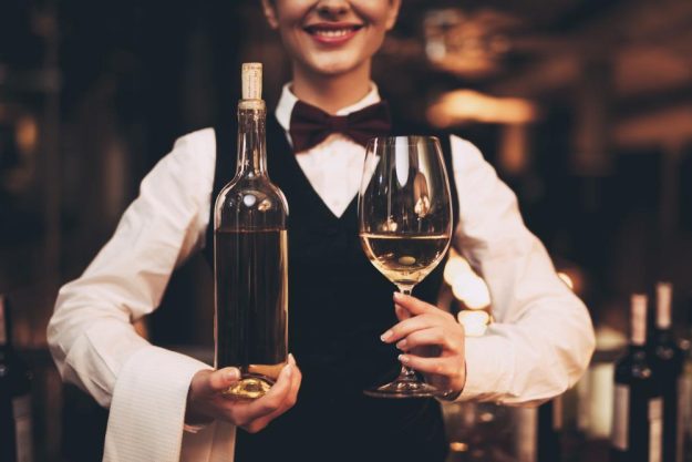 Weinprobe München – Kellnerin bringt Weißwein